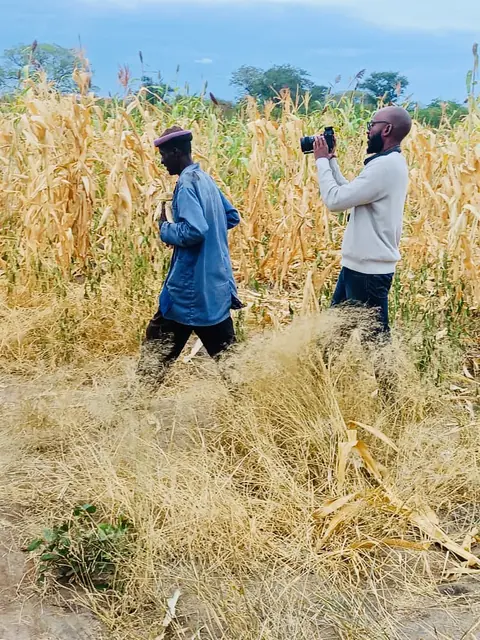 Walking through a field with a camera during a rural shoot