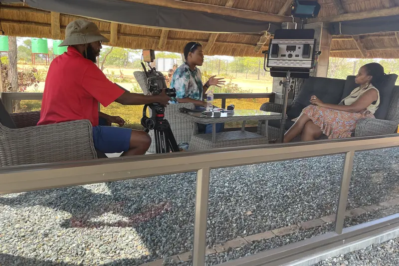 A two-camera interview set up under a thatched shelter on location in Botswana