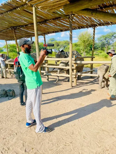 Filming handheld under a shade structure at a wildlife sanctuary